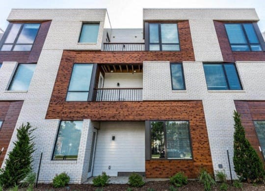a white brick building with windows and a balcony at Marcato, Kansas City, MO, 64108