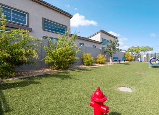 a red fire hydrant in the grass in front of a house