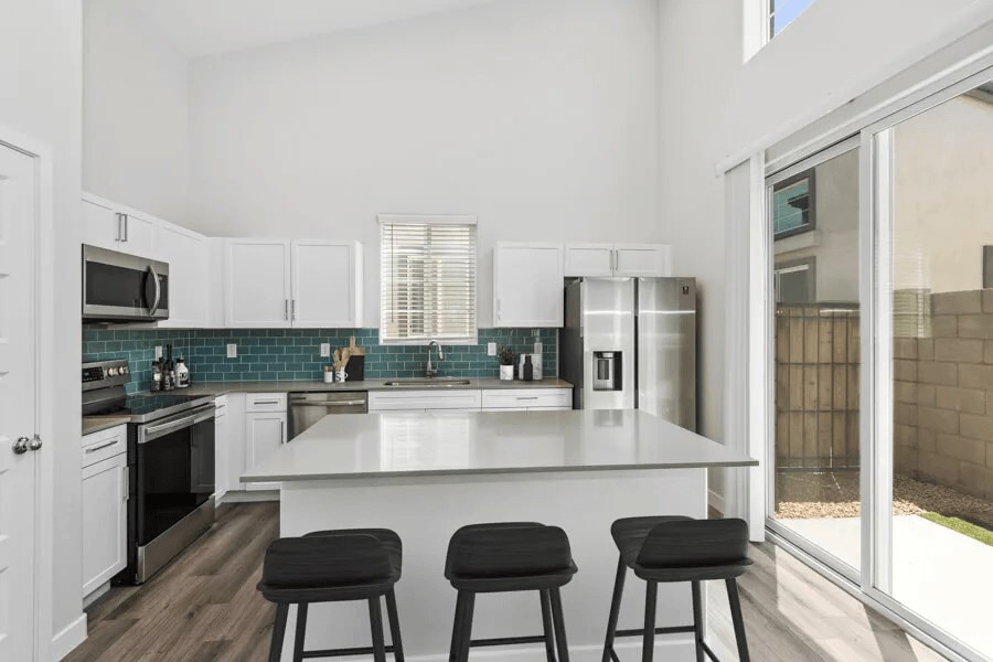 a kitchen with an island and three bar stools