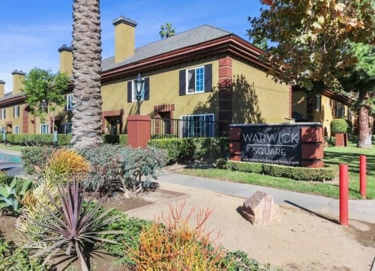 a yellow house with a sign in front of it
