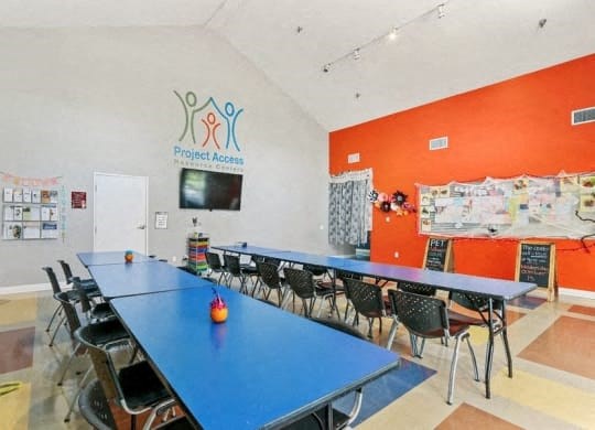 a conference room with tables and chairs and a television