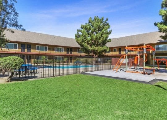 a yard with a swing set and a pool