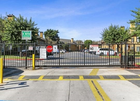 a gate in front of a parking lot with cars