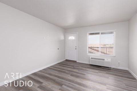 A room with a door and a window with blinds.