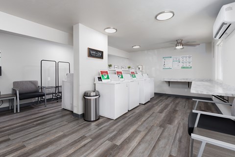 A white reception desk with a trash can and a sign on the wall.