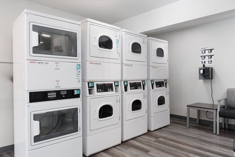 A row of white ovens are lined up in a room.