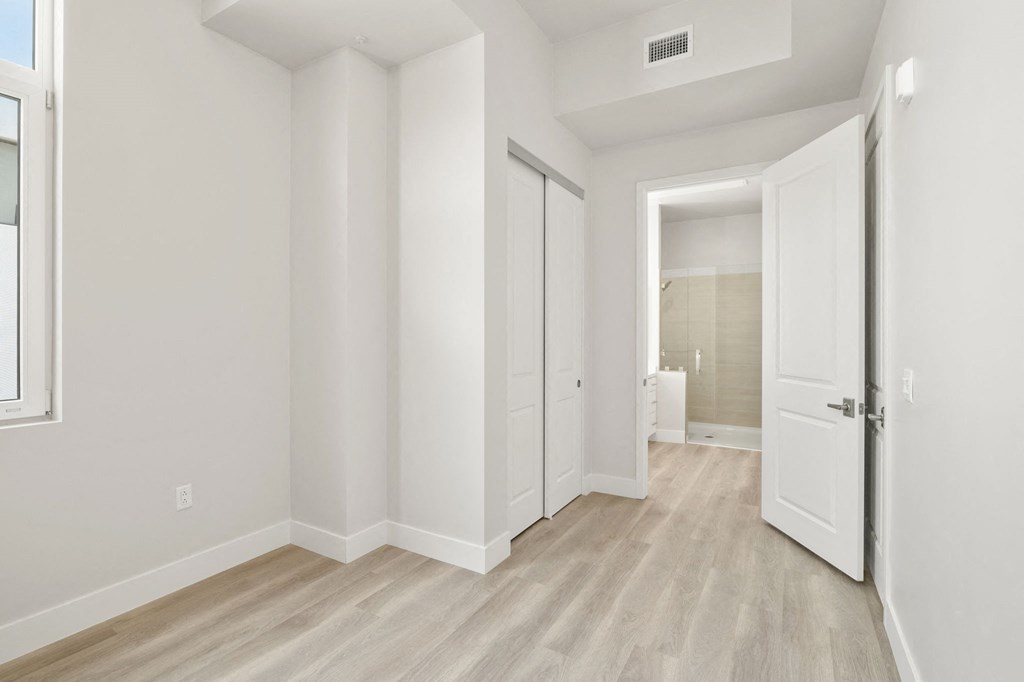 a living room with white walls and a door to a bathroom
