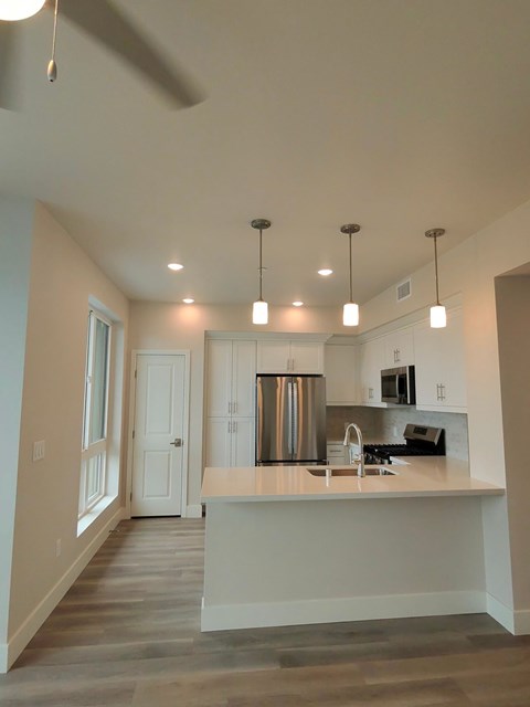 A kitchen with a white counter and a stainless steel refrigerator.