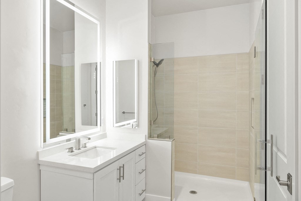 a white bathroom with a sink and a shower