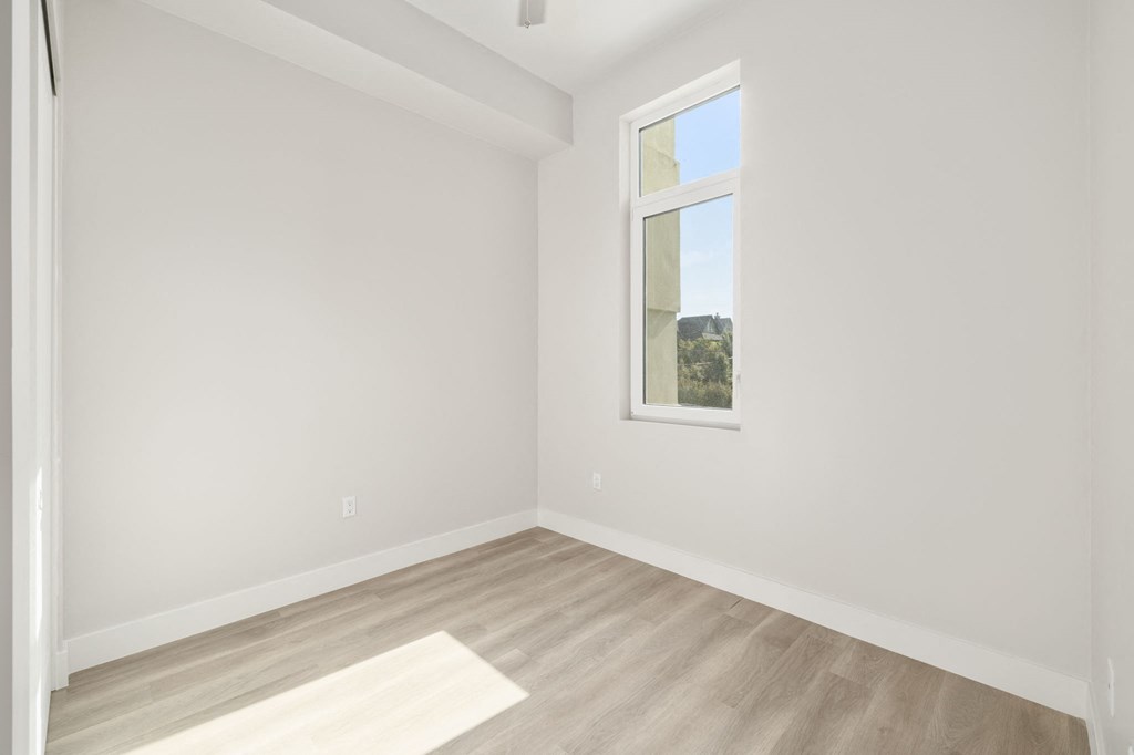 an empty room with white walls and a window