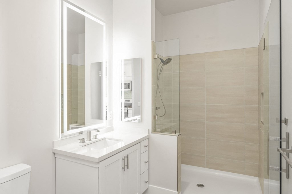 a white bathroom with a sink and a shower