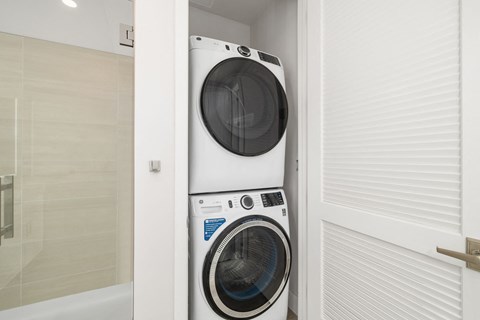a washing machine in a bathroom with a pattern of arms on the wall