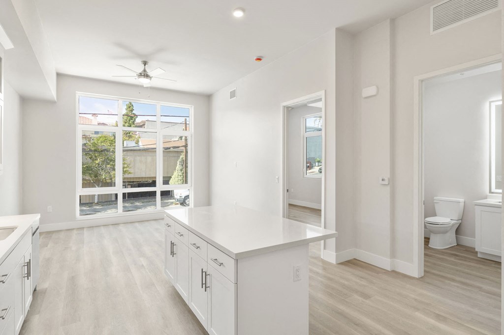 a large white kitchen with a large window and white cabinets