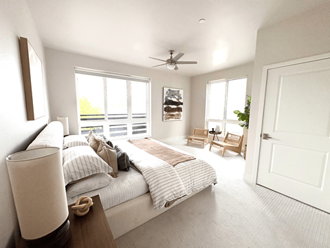A bedroom with a large bed and a ceiling fan.