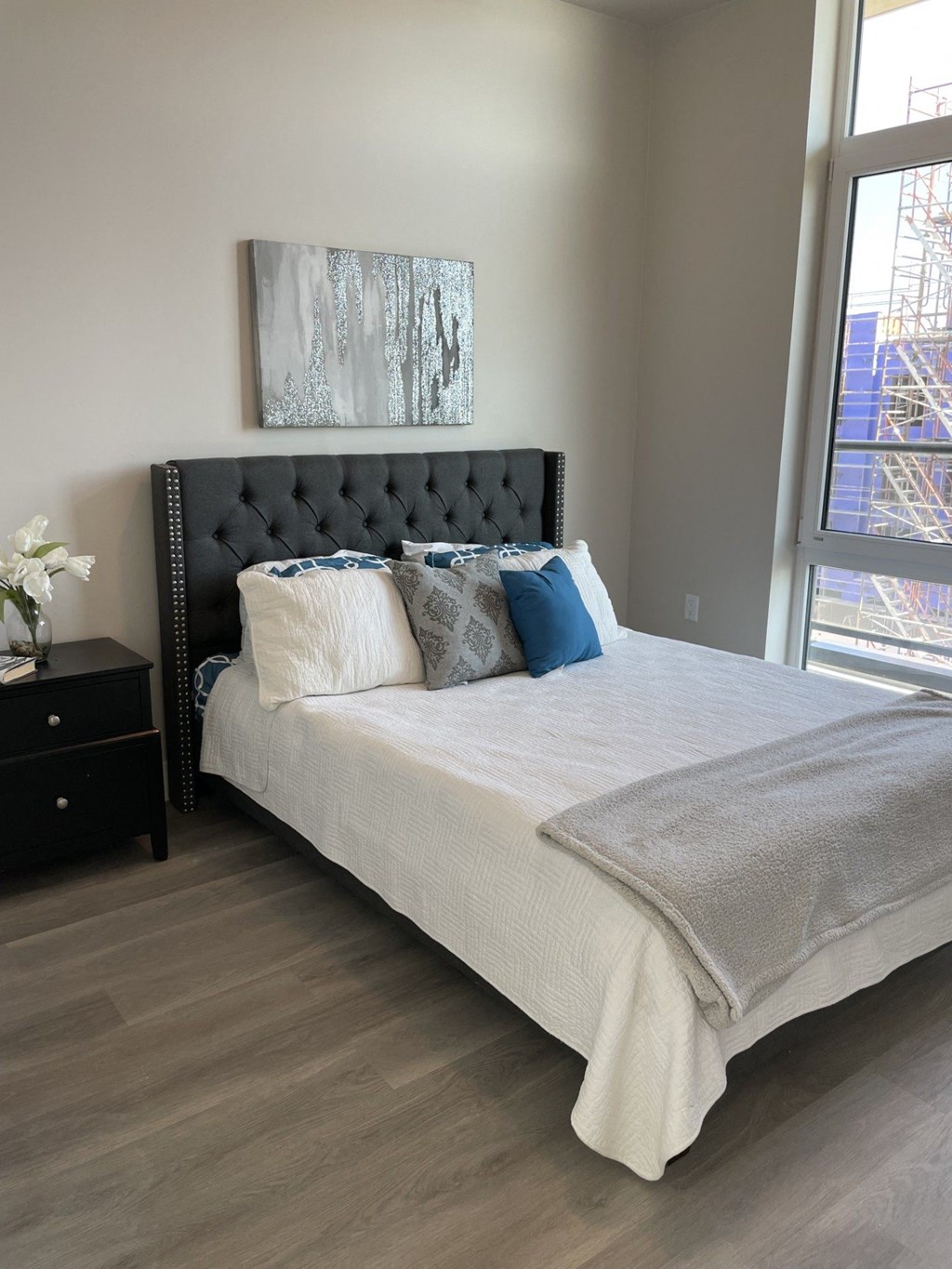 a bedroom with a bed and a large window