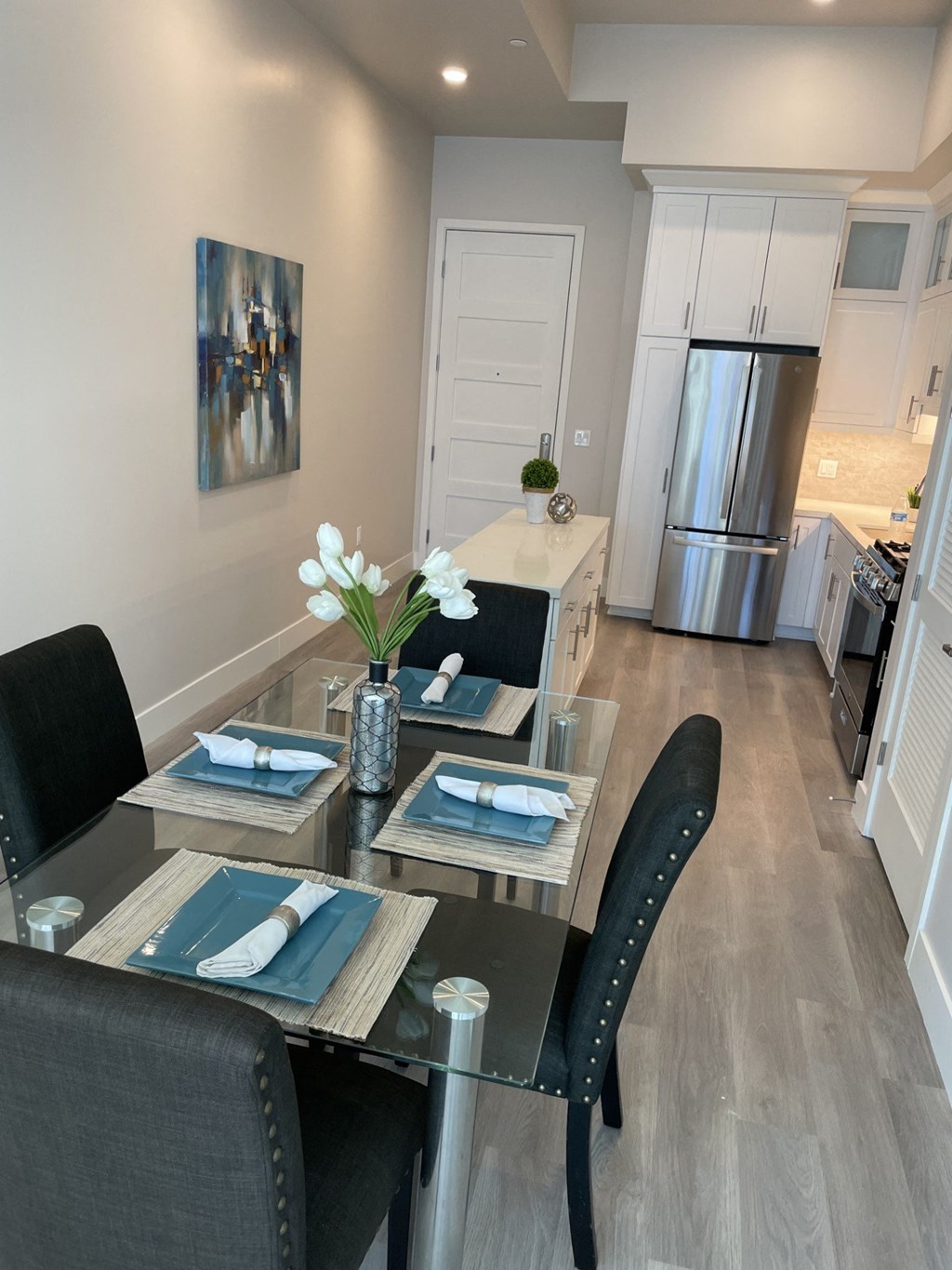 a kitchen and dining room with a glass table and chairs