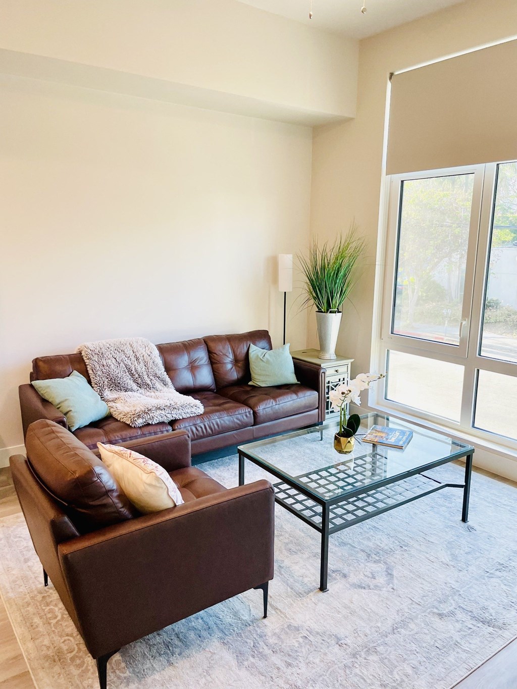 a living room with leather furniture and a glass coffee table