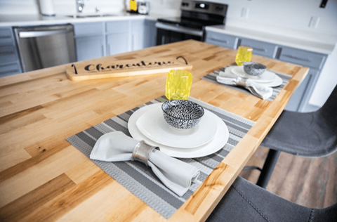 A wooden table with a plate and a napkin on it.
