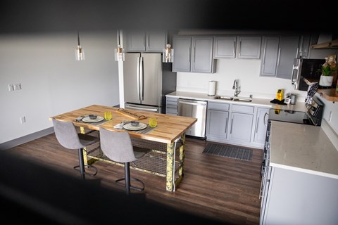 A kitchen with a table and chairs in the foreground.