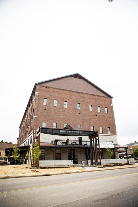 A large red brick building with a black awning on the front.