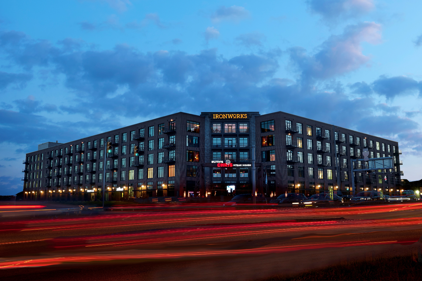 a large hotel building at night with streaks of traffic