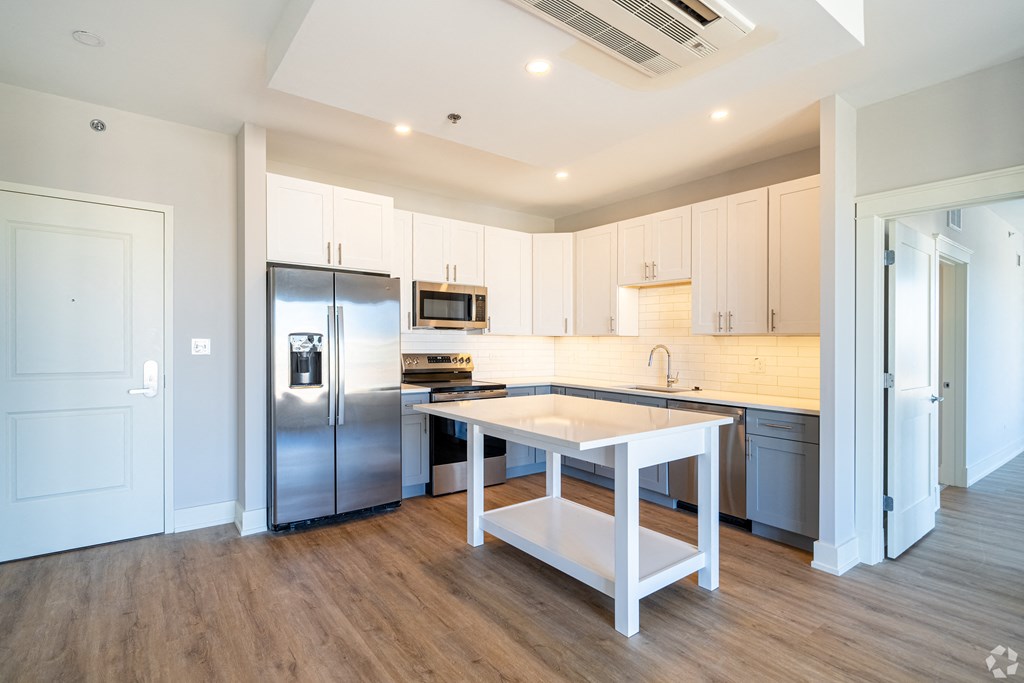 a large kitchen with stainless steel appliances and white cabinets