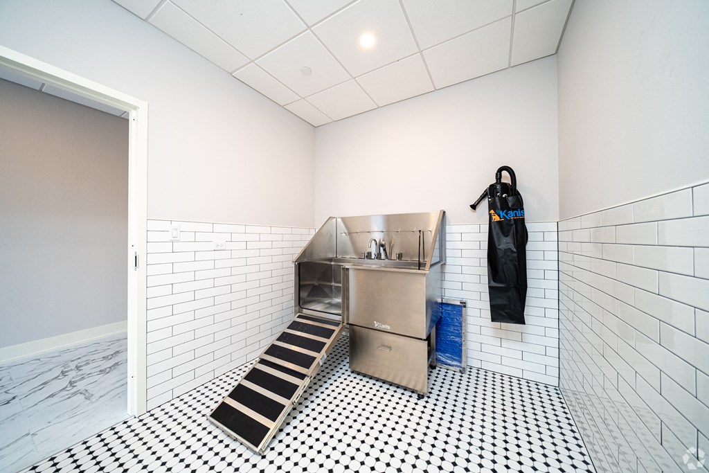 a kitchen with a sink and apron in a white room with a door