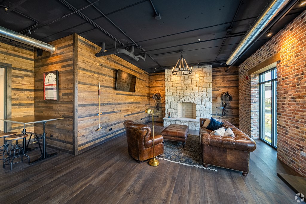 a living room with leather furniture and a stone fireplace