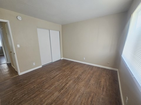 A room with a wood floor and a white closet.