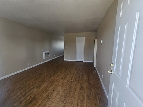 A room with wood flooring and white walls.