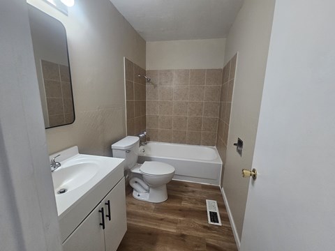 A bathroom with a white sink, toilet, and bathtub.