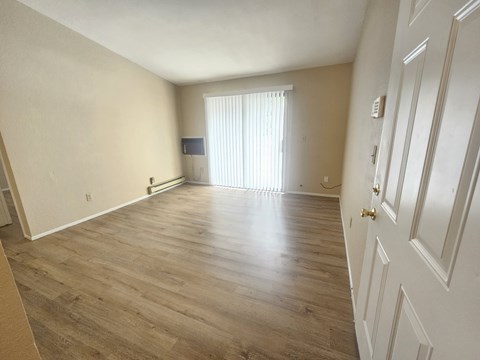 A room with wooden flooring and white walls.