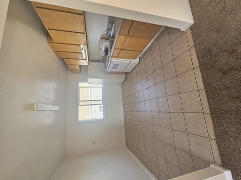 A bathroom with a window and tiled walls.