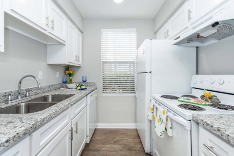 a kitchen with white appliances and granite counter tops