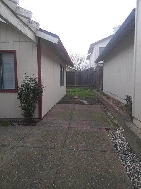 a walkway between two buildings with a yard between them