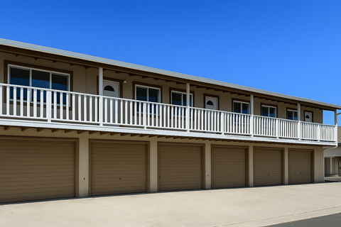 A building with a white balcony and brown doors.