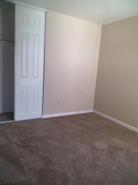 an empty room with a door and a carpeted floor
