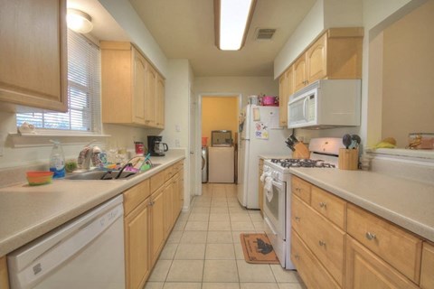 a kitchen with white appliances and wooden cabinets