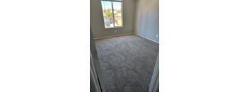 a carpeted living room with a large window