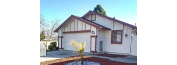 a white house with a garage and a palm tree