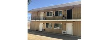 the front of a building with a balcony and two doors