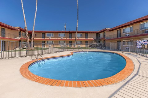 a resort style swimming pool in front of a hotel