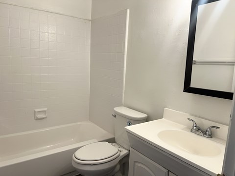 A white toilet sits next to a white sink in a bathroom.