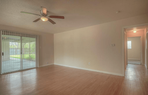 a living room with a ceiling fan and a wood floor