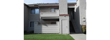 A two-story house with a balcony on the second floor.