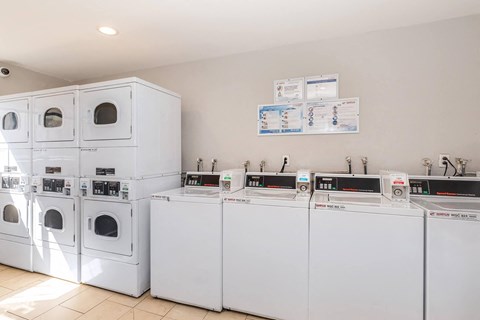 Community laundry facility with stacked dryers and washers at Oakridge Apartments, California