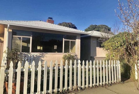 a house with a white fence in front of it