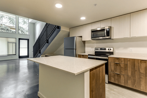 A kitchen with a white counter top and wooden cabinets.