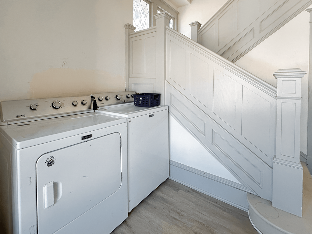 A white oven and dishwasher in a room with a staircase.