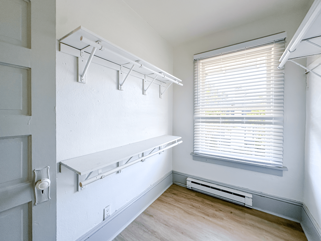 A white closet with a window and a door.